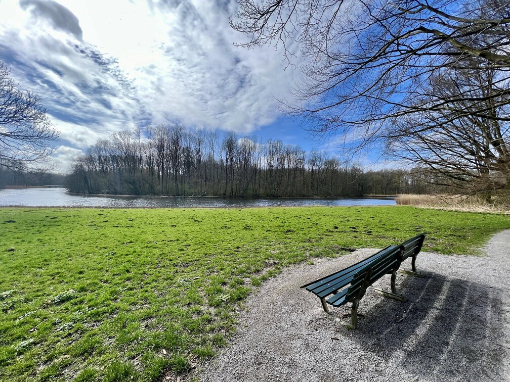 An empty bench in front of a calm river on a sunny day • Header image for: Why I Stopped Tracking Traffic on My Personal Sites • I was never happy about being tracked, why should I do that to others? • Ayo's Blog • Blogs on tech, life, and personal growth • Ayo Ayco